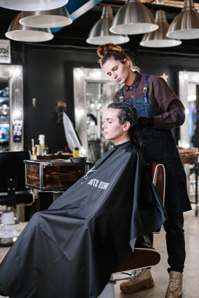 Hair stylist working on client's hair at a contemporary salon, providing professional hairdressing services.